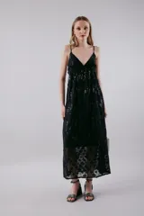 Vestido largo negro con breteles finos, escote en V y falda con transparencias y bordado de flores.