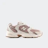 Championes New Balance 530 color beige con detalles en rosa y suela marrón.