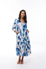 Vestido midi blanco con estampado floral en tonos de azul, corte evasé, mangas 3/4 y cuello en V.