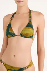 Top de bikini triangular con estampado abstracto en tonos verde y mostaza, con tirantes anudados al cuello y a la espalda, y argollas metálicas doradas en las uniones de los breteles.