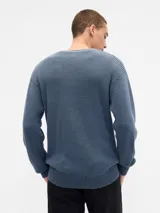 Buzo de tejido de punto con cuello en V, manga larga y puños acanalados.