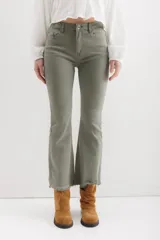 Pantalón de jean color marrón óxido, tiro medio, corte ajustado en muslos y ligeramente acampanado en la parte inferior (bootcut/flare), con bajo desflecado.