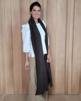 Bufandón de lana lambswool, de textura suave y liviana, con diseño liso y etiqueta de cuero en el extremo inferior.