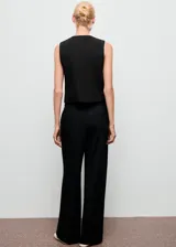 Pantalón de vestir negro de corte wide leg, con tiro medio, detalle de pinzas frontales, trabillas para cinturón y cierre delantero con botón, gancho y cremallera.