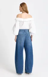 Jean de tiro alto con corte wide leg, confeccionado en denim azul clásico. Presenta costuras verticales frontales que estilizan la silueta y un diseño de pierna ancha.