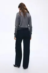 Pantalón de jean color azul marino, de tiro alto y corte wide leg, con amplios bolsillos frontales de parche y presillas para cinturón.
