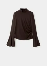 Camiseta marrón de manga larga acampanada, con cuello perkins, diseño entallado y detalle fruncido en el lateral de la cintura.