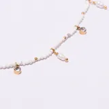 Collar tipo gargantilla con cadena de eslabones dorados, intercalada con cuentas blancas y dijes colgantes: perlas irregulares, cristales redondos engarzados y pequeñas cuentas doradas.