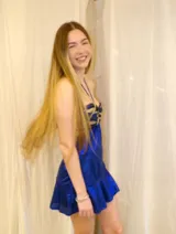 Vestido corto de color bordó metalizado, con diseño strapless, escote halter y argolla central en el busto con detalles de lentejuelas. Presenta aberturas cut-out en la cintura y falda corta con vuelo.