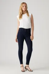 Jeans de tiro alto color azul oscuro, corte ajustado en cadera y muslos, con pierna skinny y cierre de cremallera.