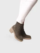 Bota corta de gamuza color verde militar, con caña de tejido elástico de punto en la parte superior, plataforma texturizada y tacón ancho.