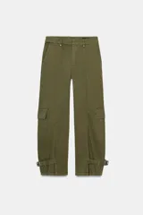 Pantalón cargo de tiro medio confeccionado en algodón, con diseño de pierna ancha y costuras verticales. Presenta bolsillos laterales y bolsillos de plastrón con solapa en las piernas. El bajo es ajustable mediante trabillas y hebillas metálicas.