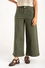 Pantalón wide leg de tiro medio en color verde oliva, confeccionado en tejido de algodón con mezcla de poliéster, liocel y elastano. Presenta diseño de cinco bolsillos, cierre frontal con botón y cremallera, y costuras a tono.