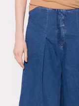 Pantalón de jean azul de corte wide leg y tiro medio-alto, con pinzas en la cintura y terminación de sastrería.