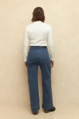 Pantalón de jean negro, ancho, de tiro alto y con dobladillo en las terminaciones.