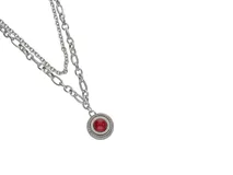 Collar de acero con cadena doble y dije redondo con media perla de pasta de coral y trenzado alrededor.