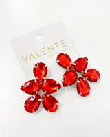 Aros colgantes con forma de flor, con engarce plateado y piedras rojas facetadas en forma de gota.