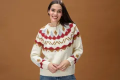 Sweater de punto color crema con diseño de inspiración nórdica y patrones geométricos en tonos rojo, gris y marrón. Presenta cuello redondo, mangas largas y terminaciones acanaladas en puños y bajo.