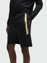 Shorts deportivos negros de felpa con cintura elástica ajustable con cordón, bolsillos laterales y logo metálico dorado de la marca Boss en la pierna izquierda.