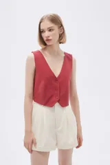 Top tipo chaleco de corte entallado, con escote en V y cierre frontal con botones a tono.