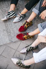 Botines acordonados con estampado de cebra en blanco y negro, puntera cubierta de glitter multicolor y suela plana color madera.