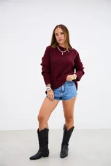 Sweater de tejido de punto acanalado en color bordó, con cuello redondo y mangas largas. Presenta un corte holgado y cómodo.