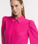 Camisa celeste de crepé con cuello inglés, manga larga abullonada y abotonadura frontal.