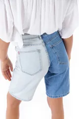 Bermuda de jean de tiro alto, con una pierna en color celeste y otra en azul.