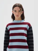 Polera de punto con diseño a rayas horizontales en tonos celeste y bordó en el cuerpo, y rayas grises y negras en las mangas. Presenta cuello redondo tejido y el logo de la marca bordado en el pecho.