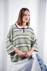 Remera rosa con rayas horizontales azul marino y bordó, cuello tipo polo marrón con botones y mangas cortas amplias.