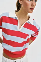 Sweater de punto con diseño de rayas horizontales en rojo y celeste, cuello polo blanco con escote en V y manga larga.