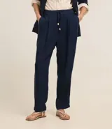 Pantalón celeste de corte recto, confeccionado en tejido de lino y viscosa. Presenta cintura elástica con lazo ajustable, bolsillos laterales y pliegues frontales.