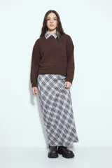 Sweater negro de tejido texturizado con líneas horizontales en relieve, de silueta levemente holgada y hombros caídos.