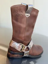 Bota de cuero marrón con estribo desmontable plateado.