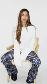 Sweater de punto color blanco, con cuello redondo, mangas largas holgadas y costuras expuestas que le aportan un detalle distintivo.