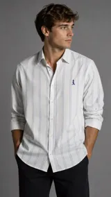 Camisa de cuello italiano para hombre, en color blanco con finas rayas verticales celestes. Presenta mangas largas, cierre frontal con botones y bordado sutil en el pecho.