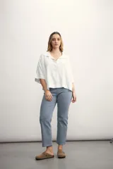 Blusa de lino blanca con cuello polo, escote en V y mangas tres cuartos de corte holgado.