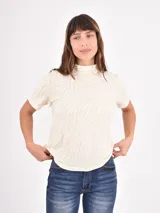 Polera de cuello alto y manga corta con estampado animal print de leopardo en tonos marrones y negros.