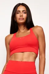 Top deportivo de alto rendimiento con diseño de espalda nadador, confeccionado en tejido técnico con protección UV50+. Presenta un bolsillo interno en el forro frontal y detalles reflectivos.