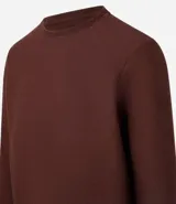 Remera de manga larga con cuello redondo y textura acanalada, confeccionada en una mezcla de poliéster y algodón.