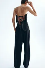 Pantalón sastrero de corte holgado color negro, con cintura clásica, cierre con botón y trabillas para cinturón. Cuenta con piernas rectas, pinzas, bolsillos al bies y raya marcada adelante y atrás.