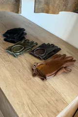 Guantes de cuero sin dedos en color marrón, negro y verde oliva.