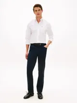 Camisa Tommy Hilfiger de corte regular, confeccionada en algodón Oxford elástico y ligero. Presenta cuello con botones, cierre frontal abotonado, mangas largas con puños redondeados y un bolsillo de parche en el pecho con el logo bordado.