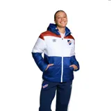 Campera puffer Umbro del Club Nacional de Football, con capucha, cierre frontal y diseño tricolor en azul, blanco y rojo. Cuenta con el logo de Umbro y el escudo del club bordados en el pecho.