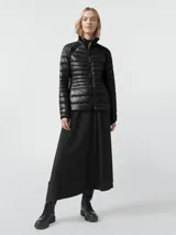 Campera acolchada de diseño técnico, color negro, con cierre frontal completo y cuello alto. Presenta paneles laterales elásticos para mayor movilidad y un acabado brillante en el cuerpo principal.