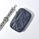 Porta celular azul con diseño acolchado en rombos, cierre superior y correa de tela estampada ajustable y desmontable.