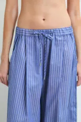 Pantalon de corte holgado y tiro medio, confeccionado en algodón con diseño de rayas verticales finas en color azul y blanco.