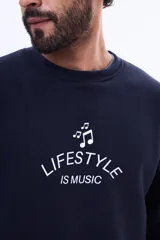 Buzo de felpa color azul marino, de cuello redondo y calce relajado. Presenta una estampa frontal en color blanco con notas musicales y el texto 'LIFESTYLE IS MUSIC'.