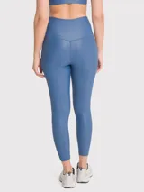 Calza deportiva azul con tela brillante, tiro alto y cintura en forma de V con silicona interior.