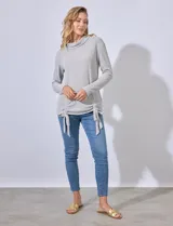 Buzo gris de tejido labrado, con cuello volcado y ruedo con terminaciones fruncidas regulables con lazo.